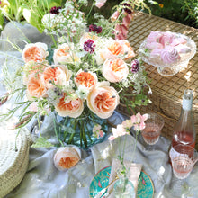 Table setting with a bouquet of Juliet roses with a distinctive full cupped rose with voluminous petals, that ombré beautifully from soft peach to warm apricot.
