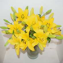 bright yellow lilies in a glass vase
