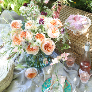 Table setting with a bouquet of Juliet roses with a distinctive full cupped rose with voluminous petals, that ombré beautifully from soft peach to warm apricot.