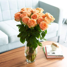 Bouquet in glass vase on table of Orange Citrus Long Stem Roses
