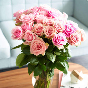 vase of pink bi colored roses with ruffled edges and light pink cream tones with darker pink on the outer petals 