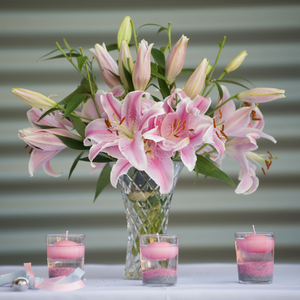 Glass vase with a bouquet of blooming pink lilies 
