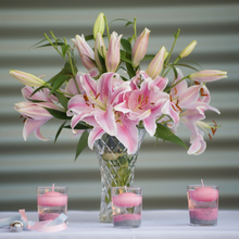 Glass vase with a bouquet of blooming pink lilies 
